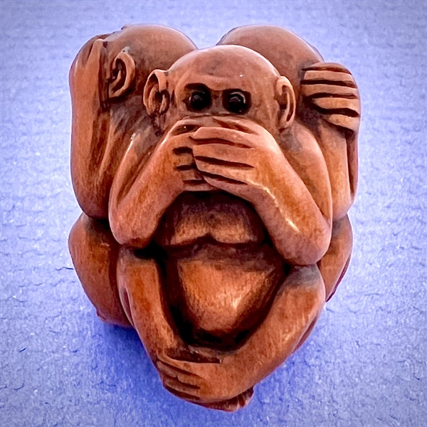 Boxwood button of three monkeys “see, hear, speak no evil.”