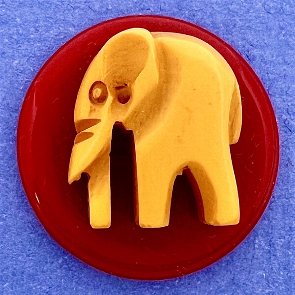 Vintage butterscotch Bakelite elephant on red Bakelite button.