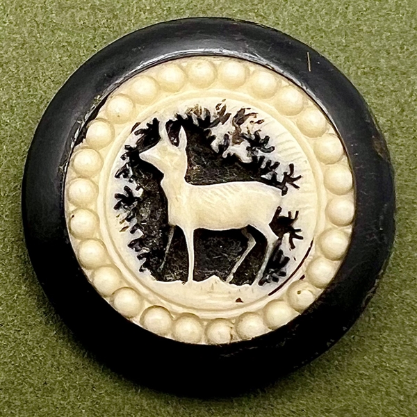 Carved natural material French sporting button of a deer.