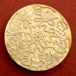 Carved natural material button of many objects and animals.