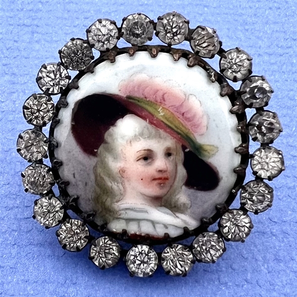 A 19th c. button of a woman huge hat with feather.