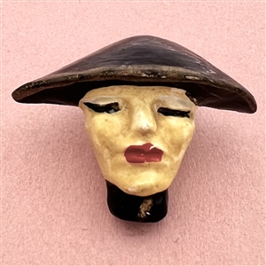 Plaster button of a woman in flat black hat.