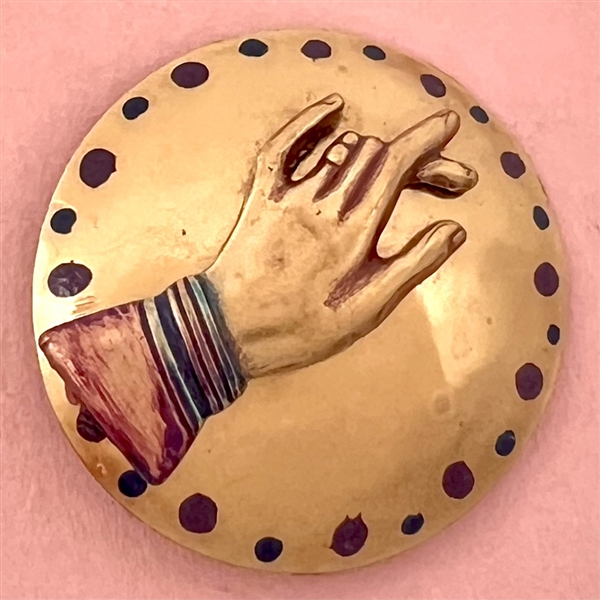 Brass studio button of a hand.