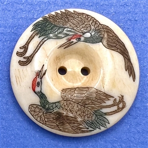 Natural material button of two red crowned cranes.