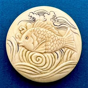 Carved natural material button of a fish swimming.