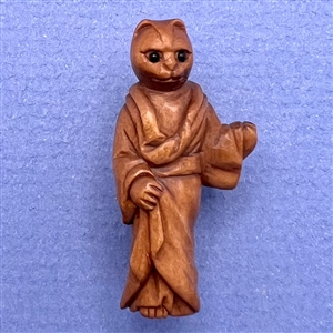 Boxwood button of a cat in a priest’s robe.