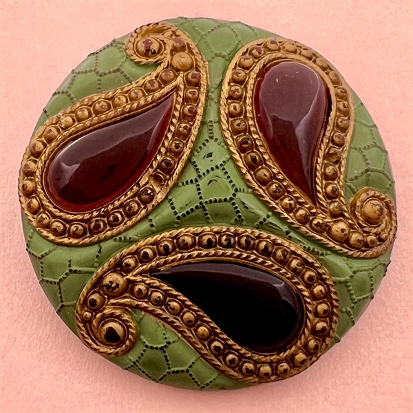 Purple glass button of three paisleys.