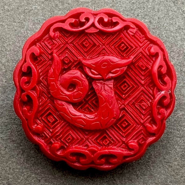 Modern “cinnabar” button of a snake.