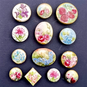 Thirteen painted porcelain studs of flowers.