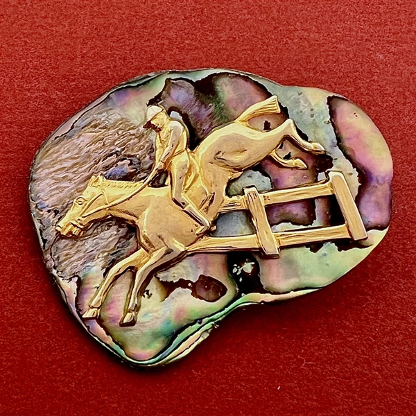 Horse and rider on abalone button.