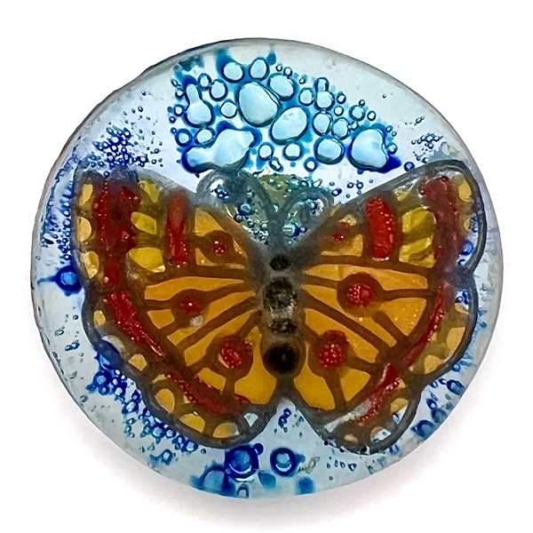 Contemporary fused glass button from an artist in Ecuador of a colorful butterfly.