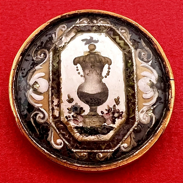 An 18th c. Reverse painted glass of an urn over silvered liner button.