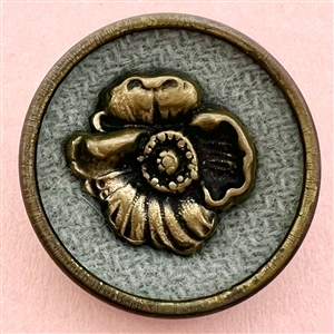 Sam Biern button of a flower over fabric.