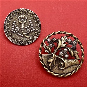 Two Victorian buttons of plant life.