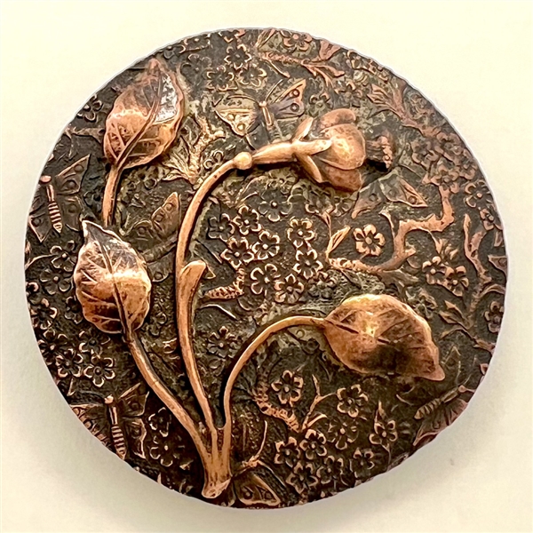 Two piece copper button of a flower with elaborate background.