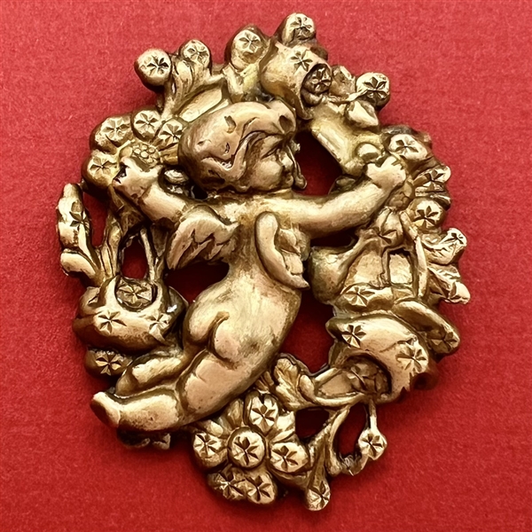 Brass button of a flying cherub tending to flowers