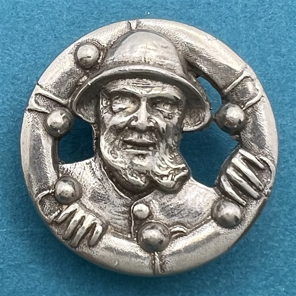 Cast pewter button of sailor inside a life preserver.