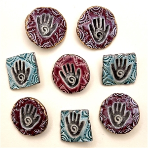 Eight handmade ceramic buttons of hand prints.