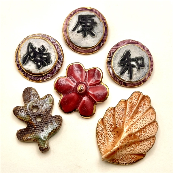 Six assorted handmade ceramic buttons of plants etc…