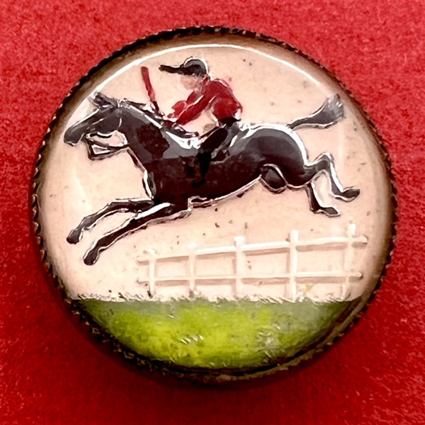 Reverse carved and painted under glass button of a jockey on horseback.