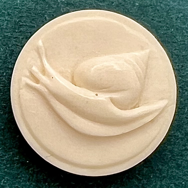 Carved natural material button of a snail.