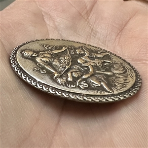 Silvered metal oval button of bountiful goddess with cherubs.