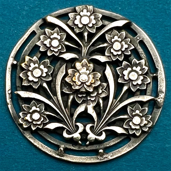 Arts and Crafts style button of flowers.