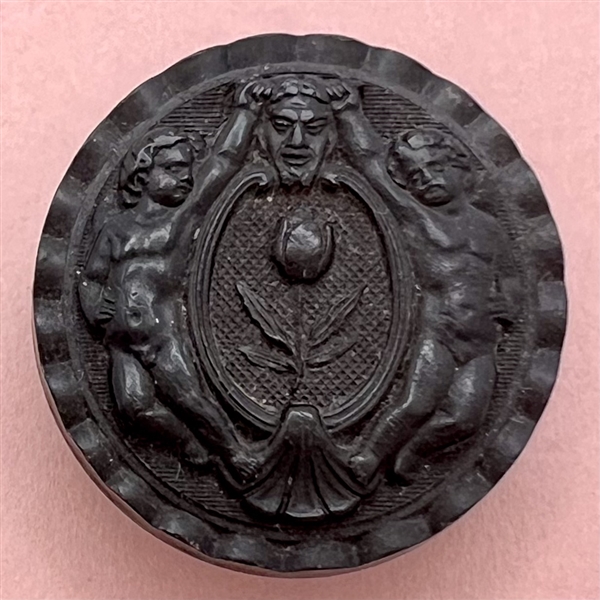 Two Putti holding the horns of a mask of Pan molded horn button.