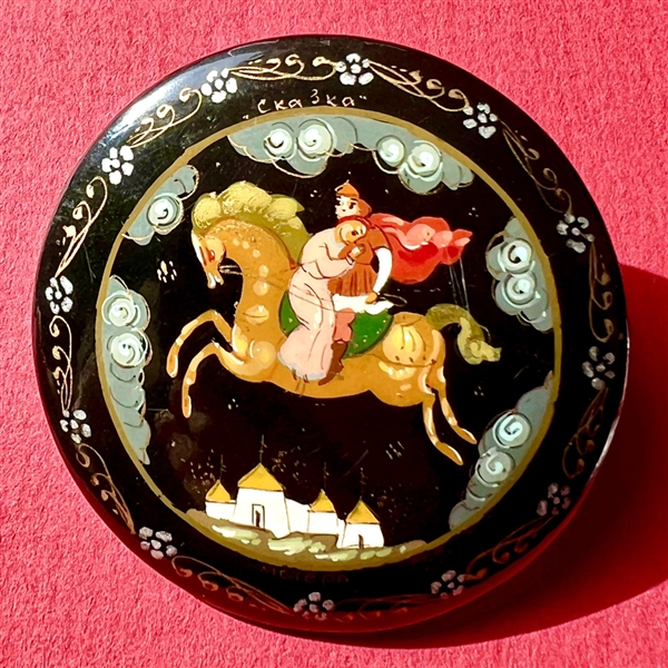 Russian lacquer button of couple on horseback flying through night sky.