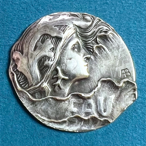 Art Nouveau silvered button of a woman with verbal “EAU” (water) by Armond Bargas.