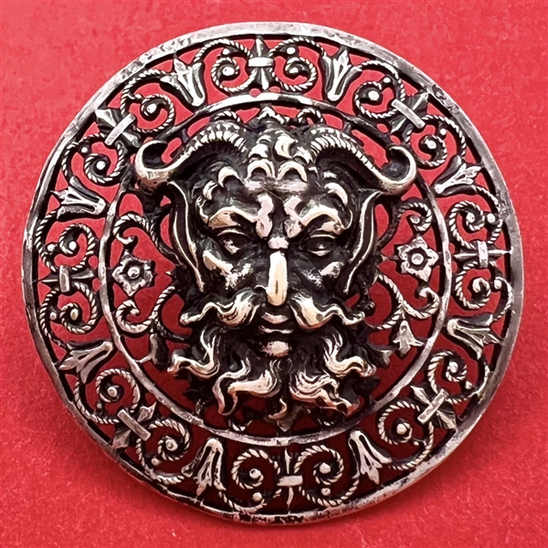 White metal with openwork button of a mythological devil.