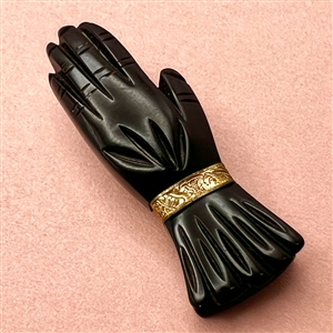 Vintage black Bakelite button of a gloved hand.