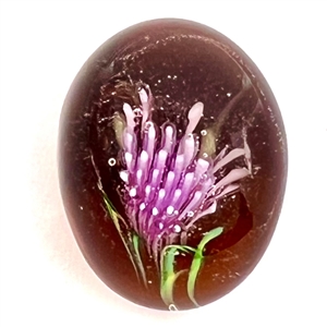 Glass paperweight studio button by Mary Gaumond of a thistle.