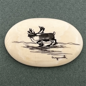 Scrimshaw button of a moose on natural material.