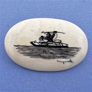 Scrimshaw button of an Eskimo spear hunting from a kayak on natural material.