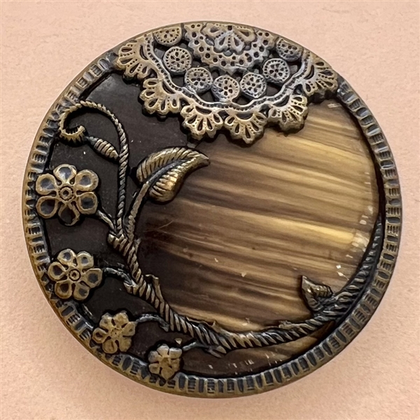 Victorian celluloid button set in tinted brass with flowers and lace.