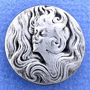 Art Nouveau style Battersea pewter button of a woman with flowing hair.