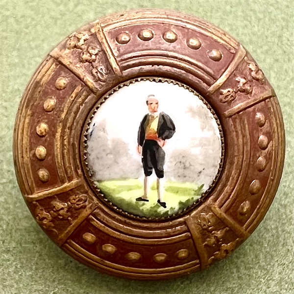 Painted porcelain button of a young man in short pants and puffy sleeves.