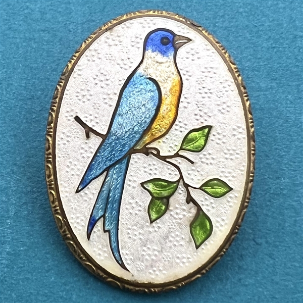 Basse-taille enamel button of a blue bird on a branch.