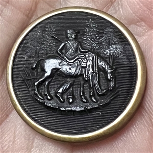 Rimmed horn sporting button of a hunter standing near horse.