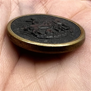 Rimmed horn sporting button of a hunter standing near horse.