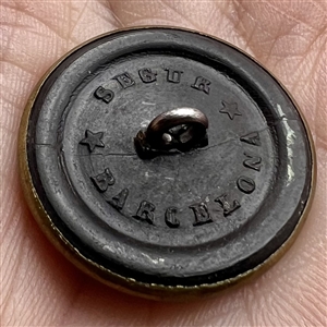 Rimmed horn sporting button of a hunter standing near horse.