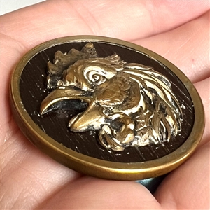 French brass button of a rooster with imitation wood background.