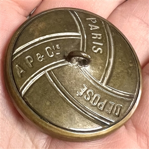 French brass button of a rooster with imitation wood background.