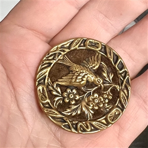 Brass button of a “Dove of peace with velvet background.