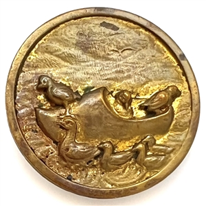 Brass button of ducks riding in a wooden clog boat.
