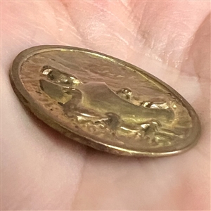 Brass button of ducks riding in a wooden clog boat.