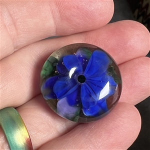 Mary Gaumond's whistle hole glass studio button of a violet.