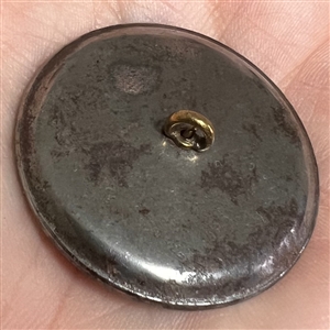 Steel cup button of a Greek woman's head.