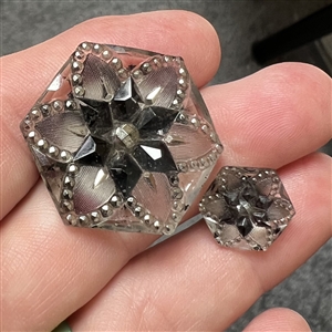 Two hexagonal lacy glass buttons in mother daughter sizes.